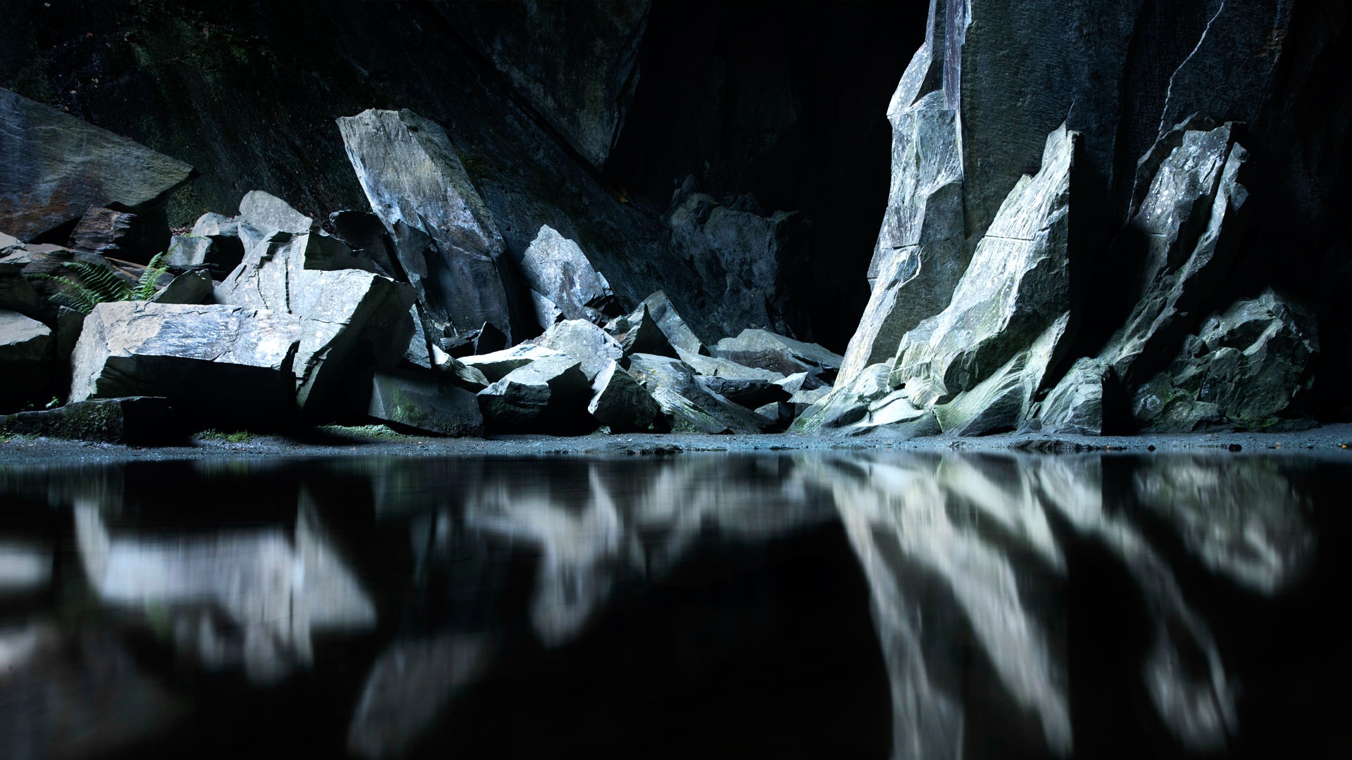 Темные плотно стоящие. Черная cкала. Необычные скалы. Отражение скалы в воде. Темные скалы.