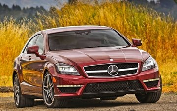 автомобиль mercedes-benz cls63 amg красного ц, стоит на обочине дороги и на заднем фоне нахо